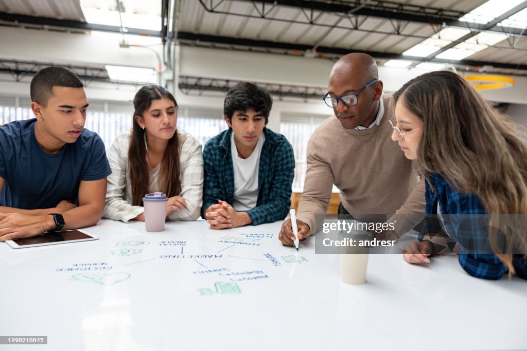 Teacher giving tutoring a group of students at a community college