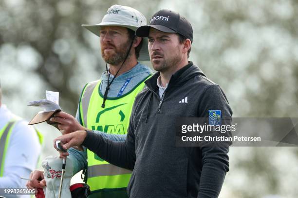 Nick Taylor of Canada and caddie wait on the fourth tee during the continuation of the weather-delayed first round of the WM Phoenix Open at TPC...