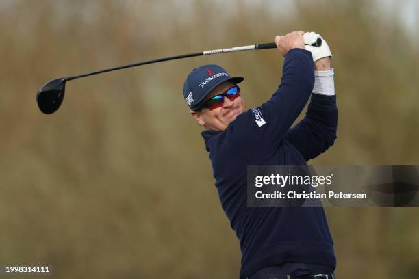 Zach Johnson of the United States plays his shot from the ninth tee during the continuation of the weather-delayed first round of the WM Phoenix Open...