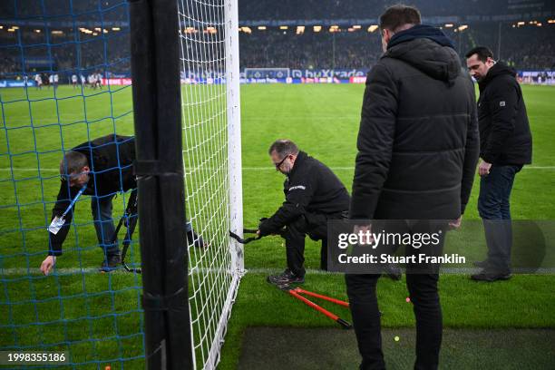 Technicians remove bicycle locks that were attached to the soccer goal during the Second Bundesliga match between Hamburger SV and Hannover 96 at...