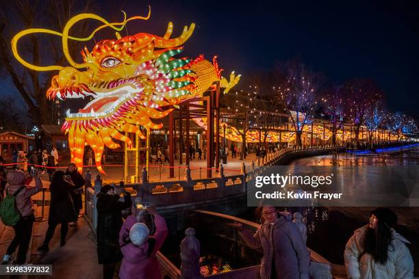 People gather around a large dragon figure for the Chinese New Year and Spring Festival at a park in a local historic area on February 9, 2024 in...