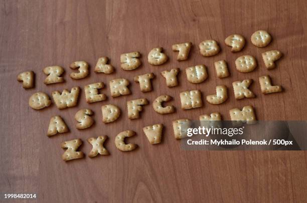 high angle view of golden coins on table - table font view stock pictures, royalty-free photos & images