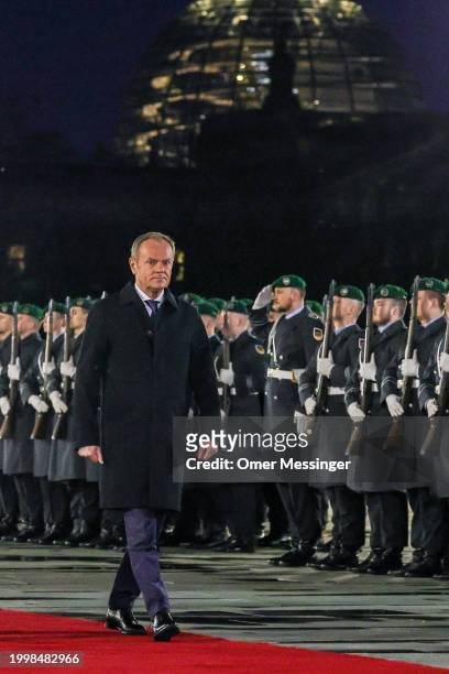 Polish Prime Minister Donald Tusk reviews a guard of honor upon his arrival for talks at the Chancellery with German Chancellor Olaf Scholz on...