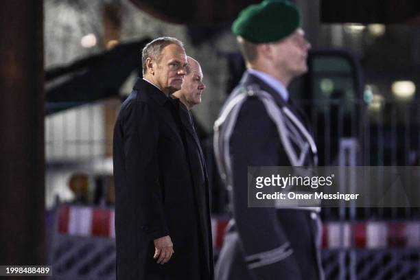 German Chancellor Olaf Scholz and Polish Prime Minister Donald Tusk review a guard of honor upon Tusk's arrival for talks at the Chancellery on...