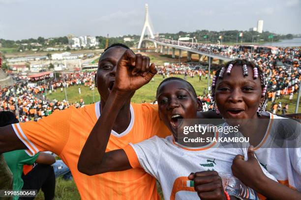 Supporters of the Ivory Coast football team, winner of the 2024 African Cup of Nations , celebrate as the players parade in a truck on the Alassane...