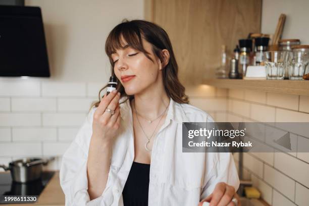 die schöne frau schnuppert den angenehmen duft für selbstgemachte kerzen - aromaöl stock-fotos und bilder