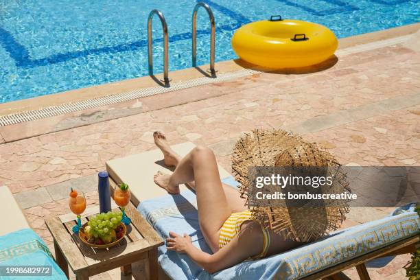 fashionable woman sitting by the pool on the empty deck - spartan cruiser stock pictures, royalty-free photos & images