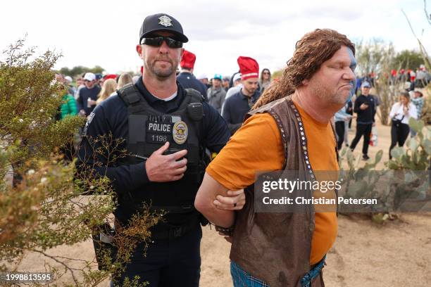 Fan dressed in costume as William Wallace from Braveheart, is apprehended by a police officer after running on the course during the second round of...