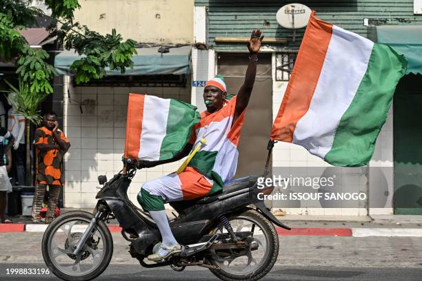 Fan celebrates Ivory Coast winning the 2024 African Cup of Nations , in the popular district of Treiville, in Abidjan, on February 12, 2024.
