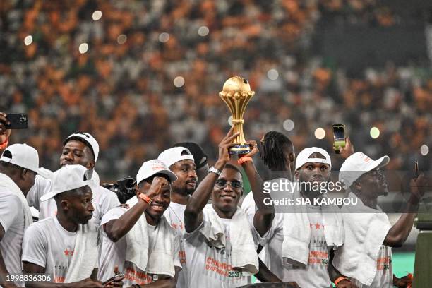 Ivory Coast's forwad Max-Alain Gradel holds the trophy at Abidjan's Felix Houphouet Boigny stadium at the end of the Africa Cup of Nations 2024...