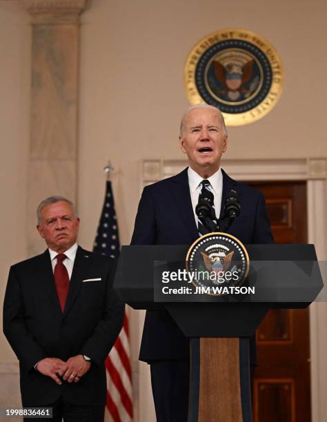 President Joe Biden speaks to the press as King Abdullah II of Jordan looks on in the Cross Hall of the White House in Washington, DC, on February...