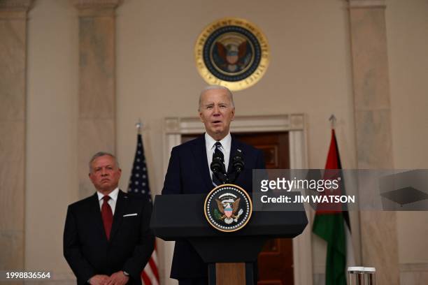 President Joe Biden speaks to the press as King Abdullah II of Jordan looks on in the Cross Hall of the White House in Washington, DC, on February...