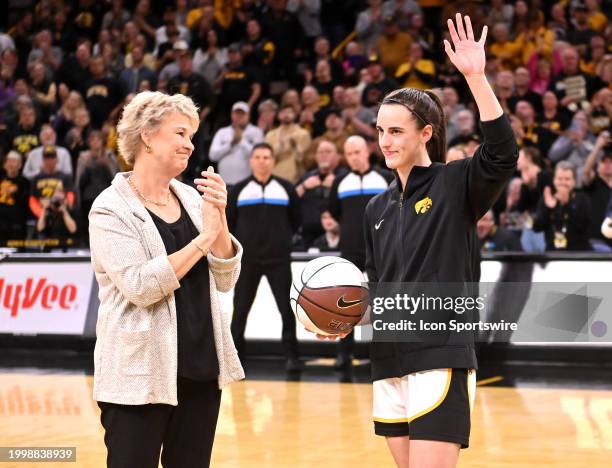 Iowa guard Caitlin Clark waves to the crowd after be recognized for breaking the Big Ten's all-time women scoring record with a special ball from...