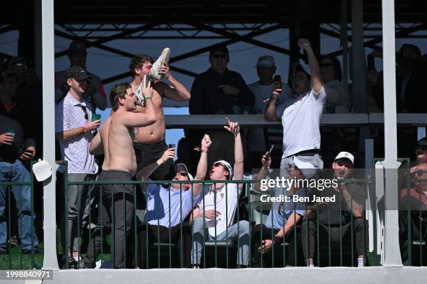 Fans drink beer from their shoes in hospitality boxes on the 16th hole during the final round of WM Phoenix Open at TPC Scottsdale on February 11,...