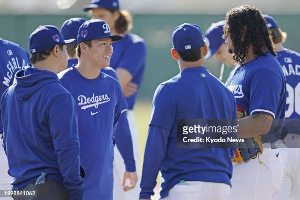 Yoshinobu Yamamoto chats with teammates at spring training with the Los Angeles Dodgers in Glendale, Arizona, on Feb. 12, 2024.