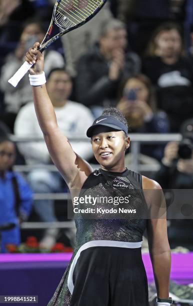 Japan's Naomi Osaka acknowledges spectators after beating Caroline Garcia of France in the women's singles first round at the Qatar Open tennis...