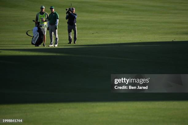 Charley Hoffman stands with his caddie on the 18th fairway during the final round of WM Phoenix Open at TPC Scottsdale on February 11, 2024 in...