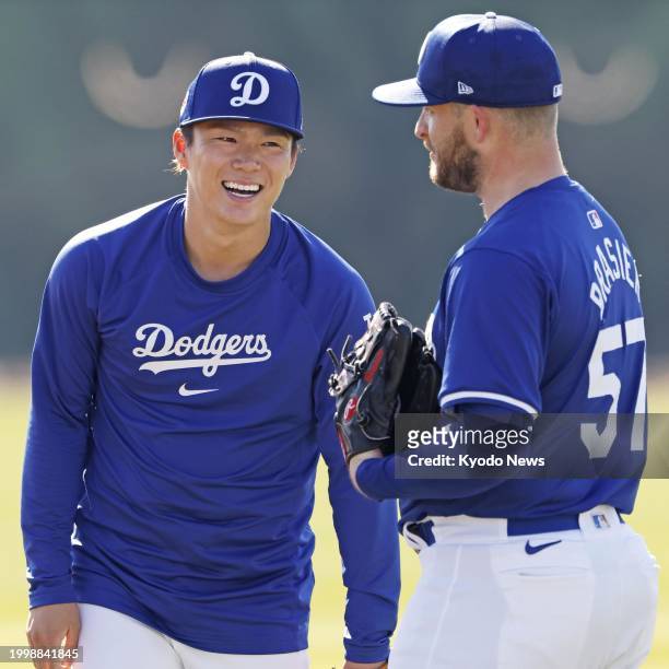 Yoshinobu Yamamoto chats with Ryan Brasier at spring training with the Los Angeles Dodgers in Glendale, Arizona, on Feb. 12, 2024.