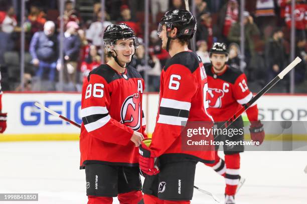 New Jersey Devils center Jack Hughes celebrates with New Jersey Devils defenseman John Marino after winning a game between the Seattle Kraken and New...