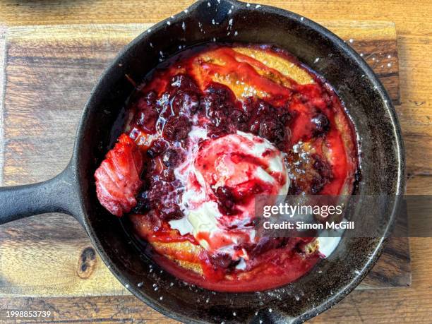 baked pancake with mixed berry compote, mascarpone, maple syrup and vanilla bean ice cream - cast iron stock pictures, royalty-free photos & images