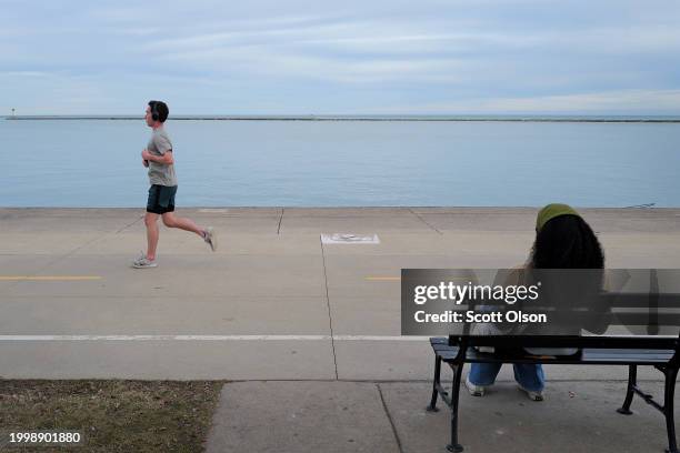 Jogger runs along the lakefront as temperatures climbed to near 60 Fahrenheit degrees, more than 20 degrees above normal on February 09, 2024 in...