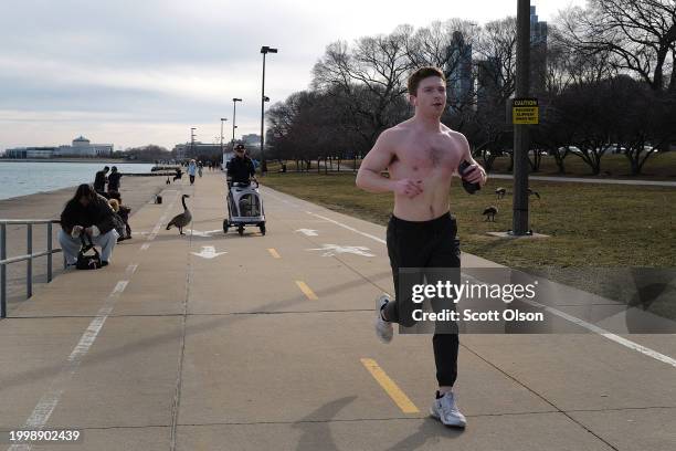 Jogger runs along the lakefront as temperatures climbed to near 60 Fahrenheit degrees, more than 20 degrees above normal on February 09, 2024 in...