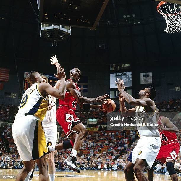 Michael Jordan of the Chicago Bulls attempts a shot against Dale Davis of the Indiana Pacers during the NBA game at Market Square Arena on March 19,...