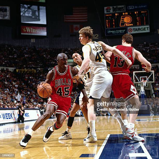 Michael Jordan of the Chicago Bulls drives past Rik Smits of the Indiana Pacers during the NBA game at Market Square Arena on March 19, 1995 in...