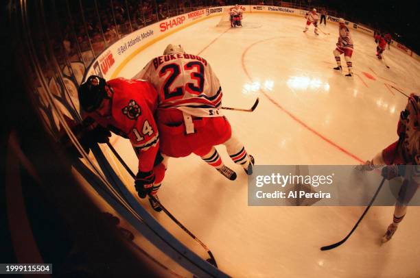 Defenseman Jeff Beukeboom of the New York Rangers battles in the corner for the puck with Center Steve Dubinsky of the Chicago Blackhawks in the game...