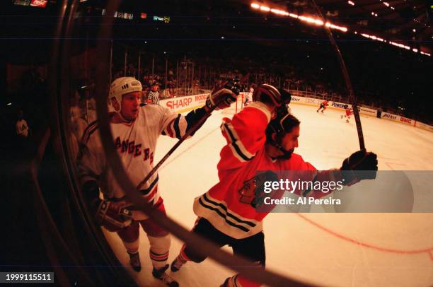 Defenseman Jeff Beukeboom of the New York Rangers battles in the corner for the puck with Center Steve Dubinsky of the Chicago Blackhawks in the game...