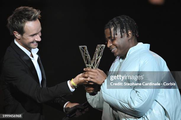 Yame celebrates as he receives the Best Male Newcomer award next to Master of Ceremony French TV host Cyril Feraud during the 39th "Les Victoires De...