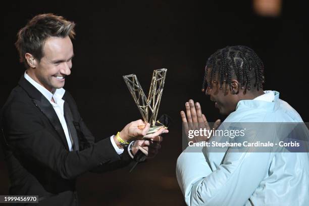 Yame celebrates as he receives the Best Male Newcomer award next to Master of Ceremony French TV host Cyril Feraud during the 39th "Les Victoires De...