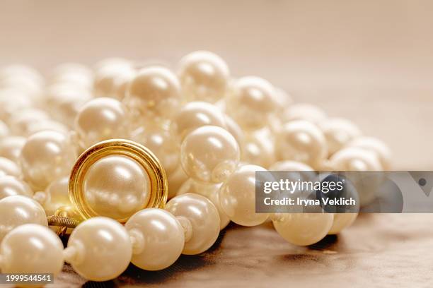 pearl jewelry on beige orange fabric in peach color. - white bead stock pictures, royalty-free photos & images