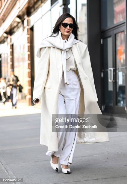 Roopal Patel is seen wearing a cream coat, white sweater, white pants and black sunglasses outside the Helmut Lang show during NYFW F/W 2024 on...