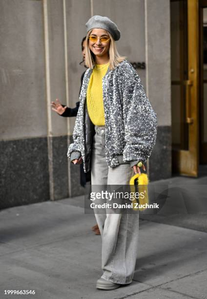 Olga Slobodianik is seen wearing a gray and white jacket, yellow sweater, gray jean and gray beret outside the Collina Strada show during NYFW F/W...