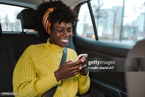 junge frau mit smartphone in einem taxi - mobility as a service stock-fotos und bilder