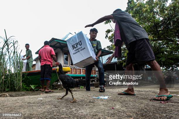 Indonesian election officials transport ballot boxes to a remote village by boat along a river ahead of Indonesian general election in Ogan Ilir,...