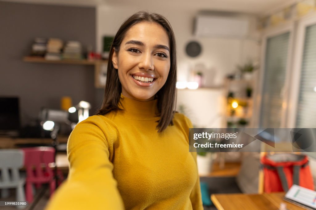 Beautiful young woman taking selfie at home