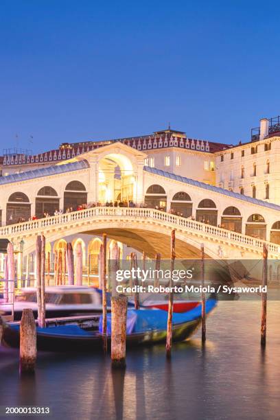 rialto bridge and gondolas on grand canal at dusk - gondel stock-fotos und bilder