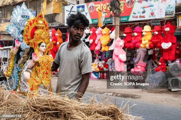 Sellers transport the idols of Goddess Saraswati ahead of Vasant Panchami on the 14th of February 2024. Gifts for Valentine's Day are also displayed...