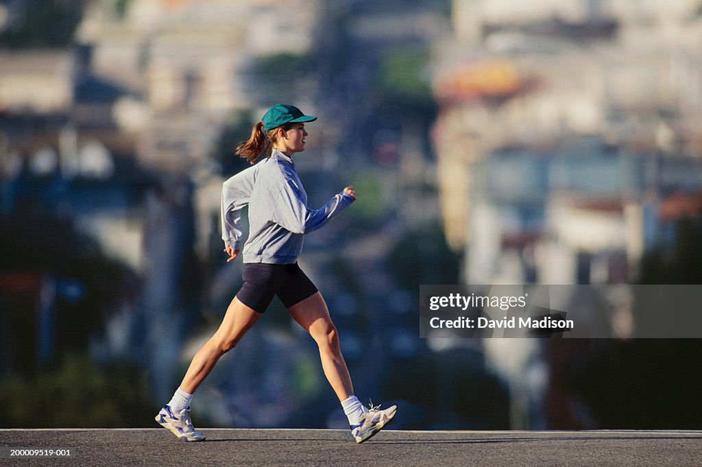 Young woman powerwalking in urban area, profile