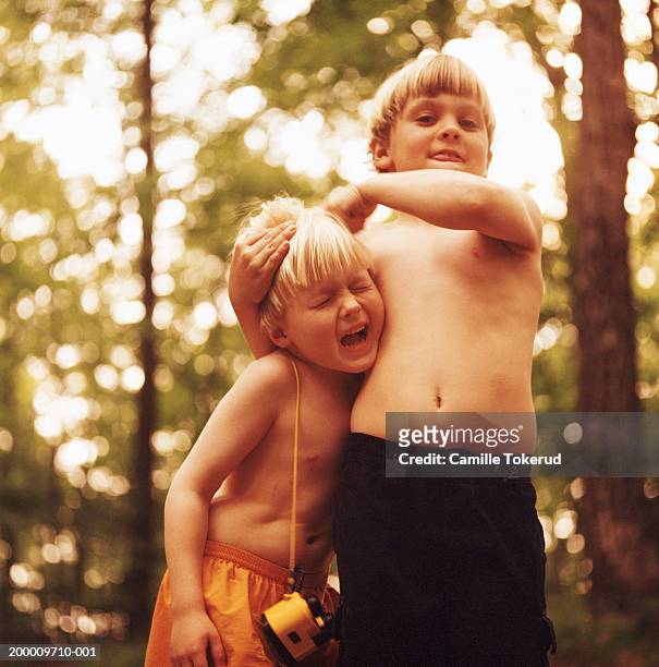 two brothers (5-9) playing outdoors - taquiner photos et images de collection