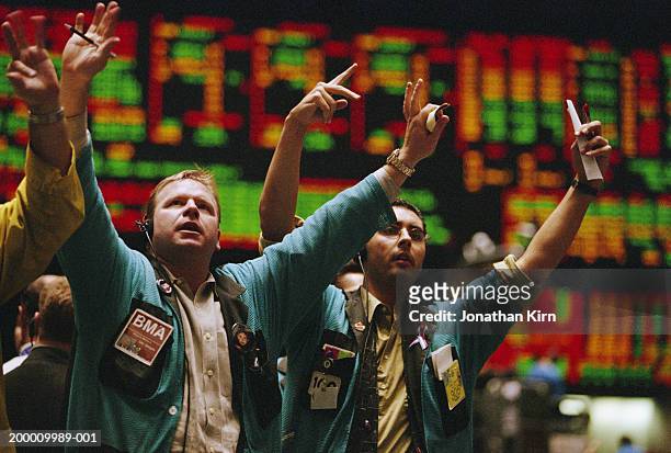 traders waving arms on exchange floor - trader foto e immagini stock