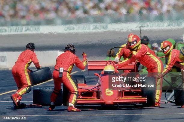 auto racing pit crew working on car at pit stop during race - pit stop stock pictures, royalty-free photos & images