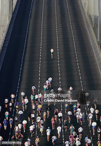 one person leading marathon over bridge (overhead view) - marathon stock-fotos und bilder