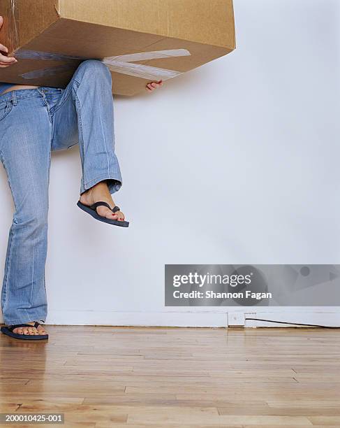 woman lifting cardboard carton, low section - box lifting technique stock-fotos und bilder