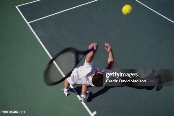 tennis player swinging racket to hit ball, overhead view - saque deporte fotografías e imágenes de stock