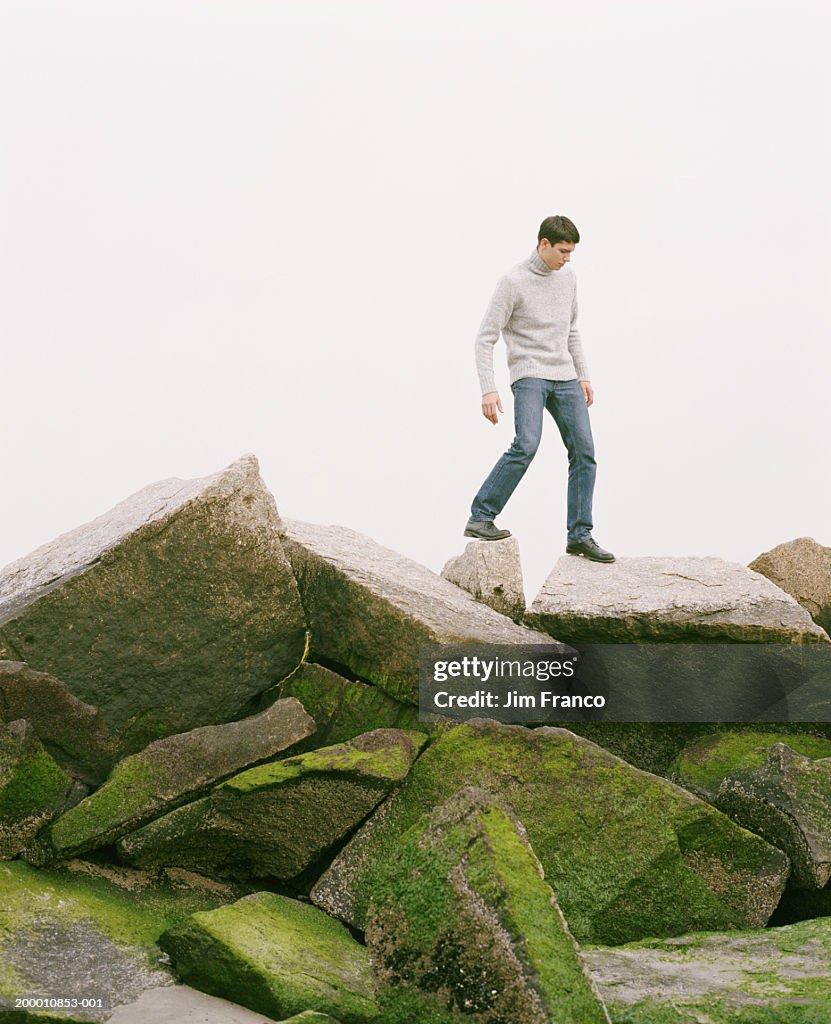 Young man walking on rocks