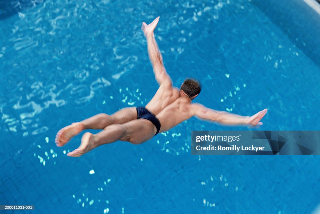 Man diving into swimming pool, elevated view