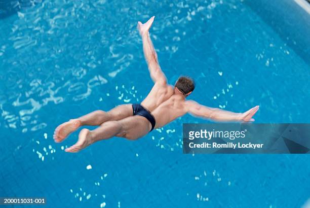 man diving into swimming pool, elevated view - dive stock pictures, royalty-free photos & images